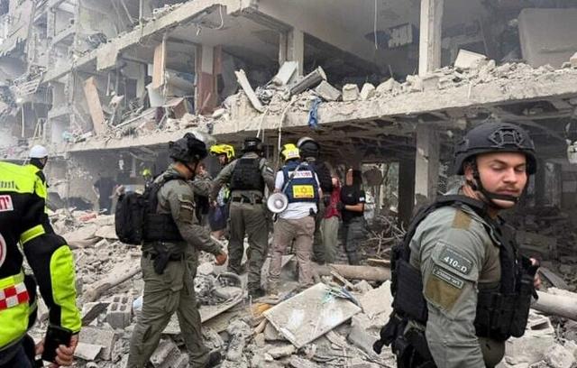 6月22日，以色列中部遭受导弹袭击现场，部分建筑坍塌，救援人员开展工作